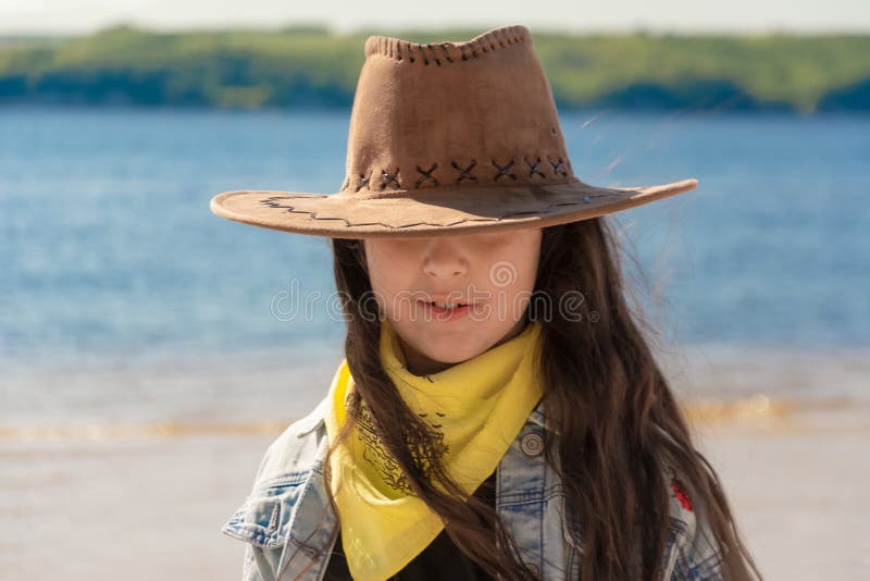 Muchacha hermosa con el pelo negro largo en un sombrero de vaquero en la playa en un d?a soleado foto de archivo libre de regalías Muchacha hermosa con el pelo negro largo en un sombrero de vaquero en la playa en un d?a soleado foto de archivo libre de regalías