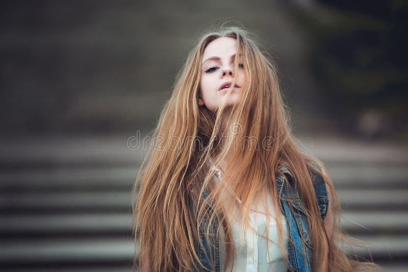 Muchacha hermosa con el pelo rubio largo que sopla por el viento Imagen entonada foto de archivo Muchacha hermosa con el pelo rubio largo que sopla por el viento Imagen entonada foto de archivo