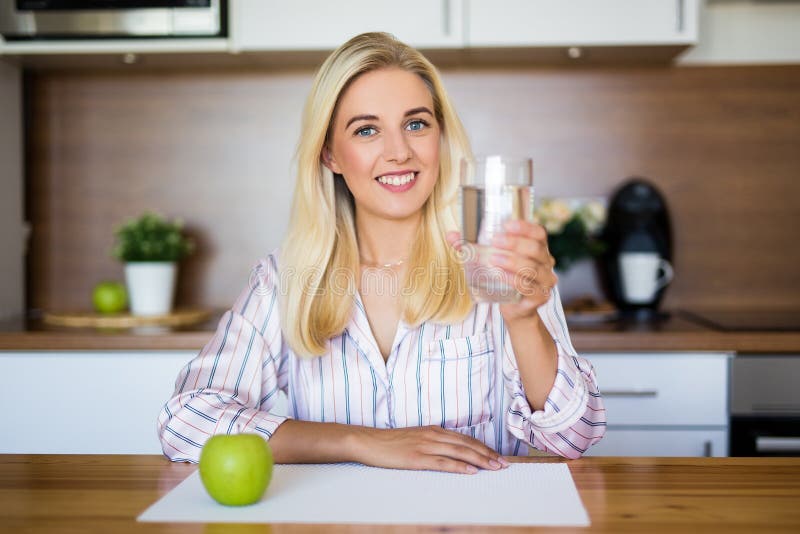 Muchacha hermosa con la manzana y vidrio de agua imagen de archivo libre de regalías Muchacha hermosa con la manzana y vidrio de agua imagen de archivo libre de regalías