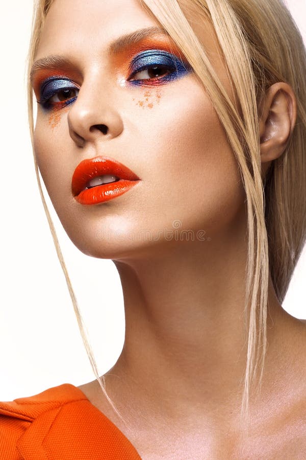 Muchacha hermosa con maquillaje coloreado brillante y labios anaranjados Cara de la belleza fotografía de archivo libre de regalías Muchacha hermosa con maquillaje coloreado brillante y labios anaranjados Cara de la belleza fotografía de archivo libre de regalías