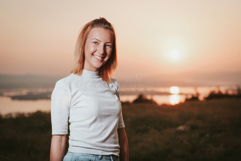 Muchacha hermosa con pelo rubio Retrato de una chica atractiva con el pelo rubio sobre fondo de puesta de sol Ella sonríe en el imagen de archivo libre de regalías Muchacha hermosa con pelo rubio Retrato de una chica atractiva con el pelo rubio sobre fondo de puesta de sol Ella sonríe en el imagen de archivo libre de regalías