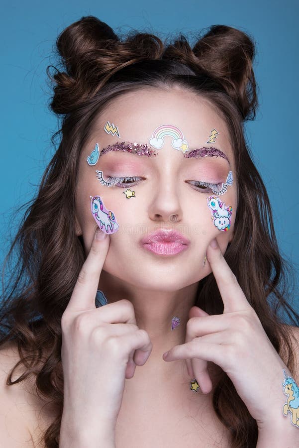 Muchacha hermosa de la moda con las etiquetas engomadas profesionales divertidas del maquillaje y del emoji pegadas en la cara imagenes de archivo Muchacha hermosa de la moda con las etiquetas engomadas profesionales divertidas del maquillaje y del emoji pegadas en la cara imagenes de archivo