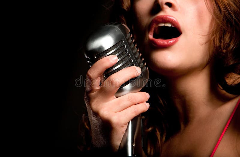 Muchacha hermosa del cantante que canta con el micrófono foto de archivo libre de regalías Muchacha hermosa del cantante que canta con el micrófono foto de archivo libre de regalías
