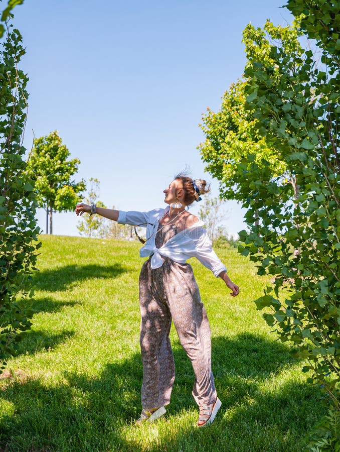 Muchacha hermosa del estilo del boho que disfruta de la libertad en un d?a soleado Mujer alegre que salta en una hierba verde foto de archivo libre de regalías Muchacha hermosa del estilo del boho que disfruta de la libertad en un d?a soleado Mujer alegre que salta en una hierba verde foto de archivo libre de regalías