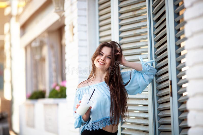 Muchacha hermosa del retrato con el pelo largo en un equipo casual que presenta en el café italiano La morenita hermosa guarda el imagen de archivo libre de regalías Muchacha hermosa del retrato con el pelo largo en un equipo casual que presenta en el café italiano La morenita hermosa guarda el imagen de archivo libre de regalías