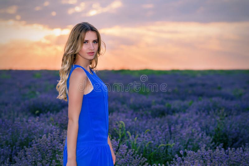 Muchacha hermosa en campo de la lavanda en la puesta del sol imágenes de archivo libres de regalías Muchacha hermosa en campo de la lavanda en la puesta del sol imágenes de archivo libres de regalías