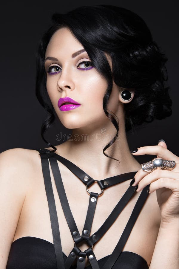 Muchacha hermosa en el estilo gótico con los accesorios de cuero y el maquillaje brillante Cara de la belleza fotografía de archivo Muchacha hermosa en el estilo gótico con los accesorios de cuero y el maquillaje brillante Cara de la belleza fotografía de archivo