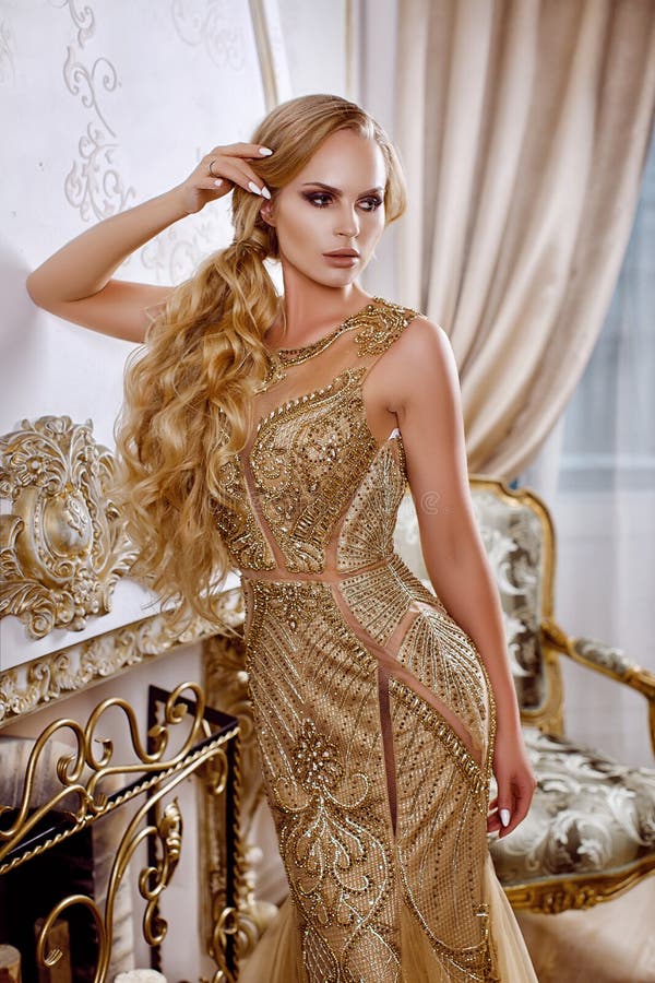 Muchacha hermosa en un vestido largo del oro imágenes de archivo libres de regalías Muchacha hermosa en un vestido largo del oro imágenes de archivo libres de regalías