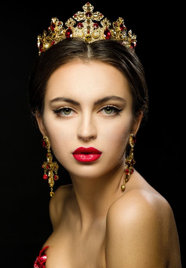 Muchacha hermosa en una corona de oro y pendientes en un backgrou oscuro imagen de archivo Muchacha hermosa en una corona de oro y pendientes en un backgrou oscuro imagen de archivo