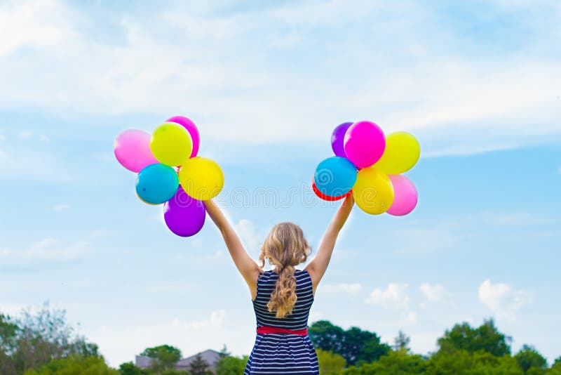Muchacha hermosa que juega con los globos coloridos en el día de verano contra el cielo azul imagen de archivo libre de regalías Muchacha hermosa que juega con los globos coloridos en el día de verano contra el cielo azul imagen de archivo libre de regalías