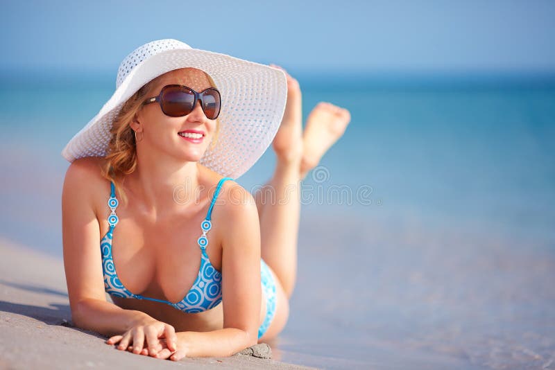 Muchacha hermosa que miente en resaca en la playa fotos de archivo libres de regalías Muchacha hermosa que miente en resaca en la playa fotos de archivo libres de regalías