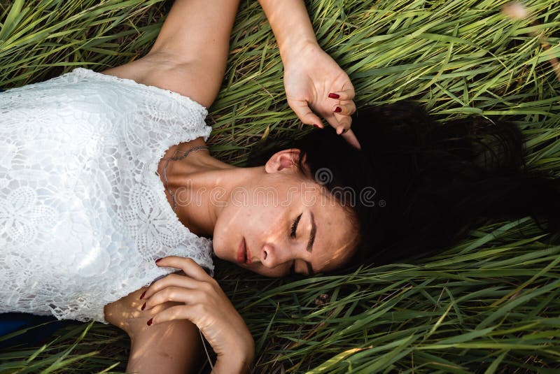 Muchacha hermosa que se acuesta en la hierba imagen de archivo libre de regalías Muchacha hermosa que se acuesta en la hierba imagen de archivo libre de regalías