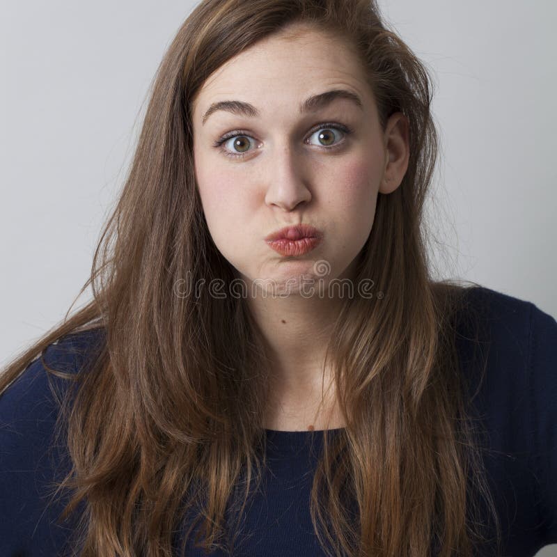 Surprise and disappointment concept - amazed young woman with cheeks puffed or blowing out cheeks for silly confusion,studio shot. Surprise and disappointment concept - amazed young woman with cheeks puffed or blowing out cheeks for silly confusion,studio shot