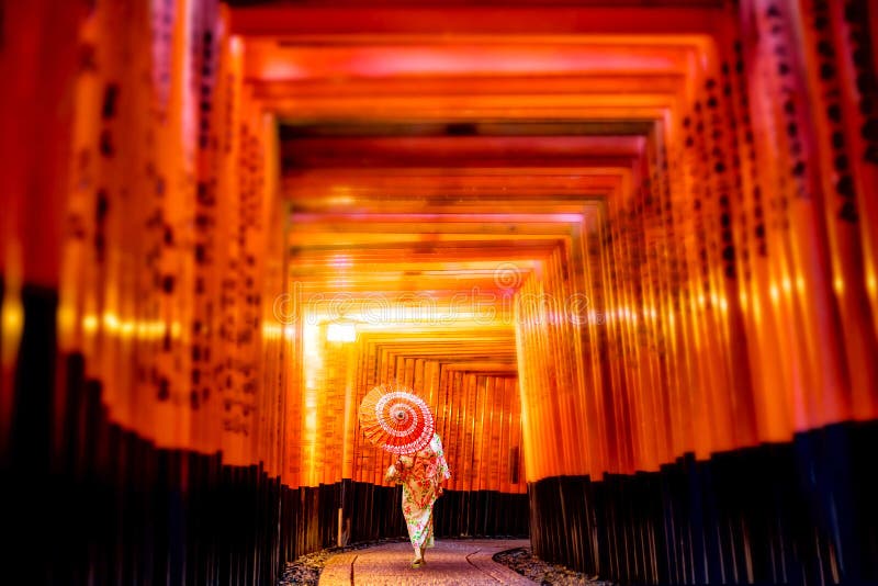 Muchacha japonesa en Yukata con el paraguas rojo en Fushimi Inari Shrin imagen de archivo libre de regalías Muchacha japonesa en Yukata con el paraguas rojo en Fushimi Inari Shrin imagen de archivo libre de regalías