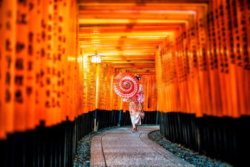Muchacha japonesa en Yukata con el paraguas rojo en Fushimi Inari Shrin foto de archivo libre de regalías Muchacha japonesa en Yukata con el paraguas rojo en Fushimi Inari Shrin foto de archivo libre de regalías