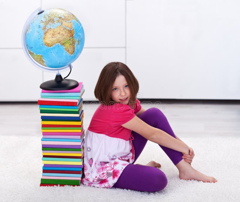 Young student girl with lots to learn - sitting near a book stack. Young student girl with lots to learn - sitting near a book stack