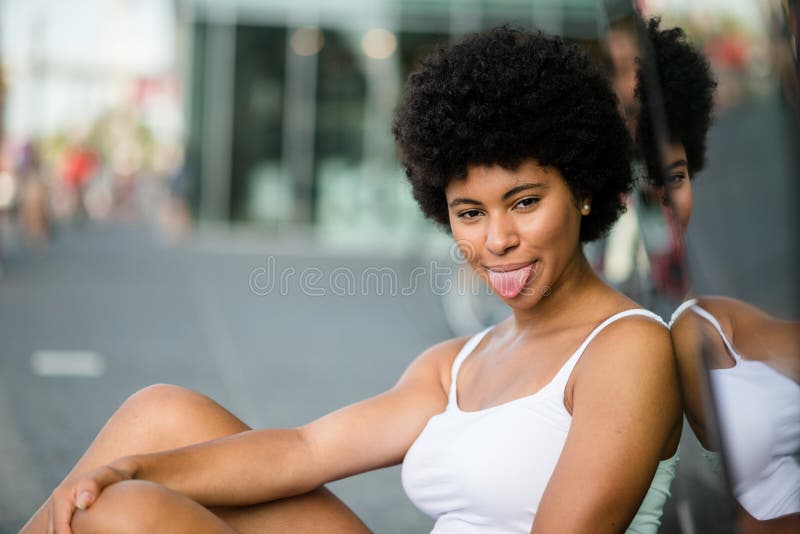 Muchacha juguetona que se pega hacia fuera la lengua en travesura imagen de archivo Muchacha juguetona que se pega hacia fuera la lengua en travesura imagen de archivo
