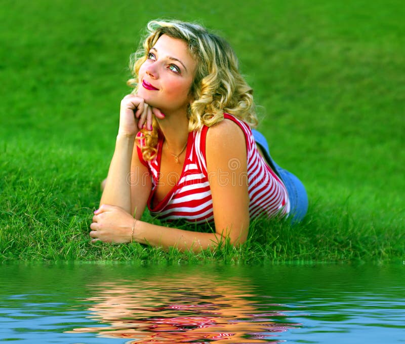 Muchacha linda en la hierba verde cerca del rivershore foto de archivo Muchacha linda en la hierba verde cerca del rivershore foto de archivo