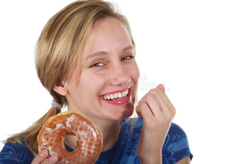 Pretty blond girl holding a doughnut with a guilty look on her face. Pretty blond girl holding a doughnut with a guilty look on her face