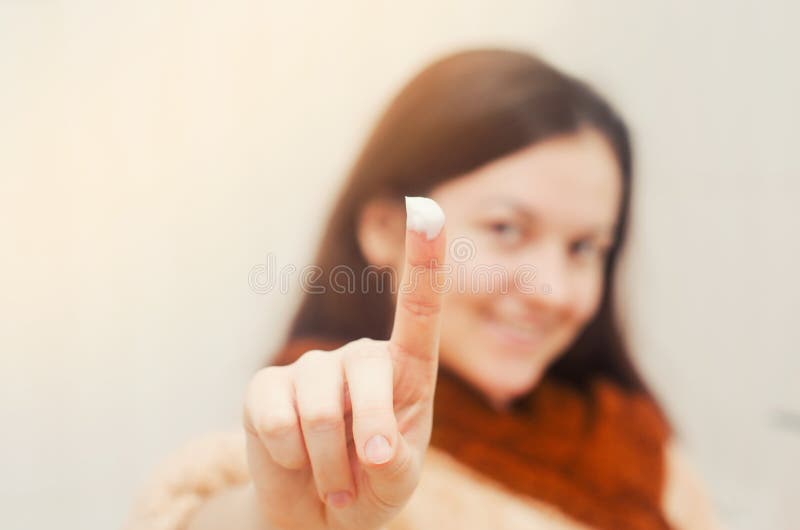 Muchacha morena europea, finger en el concepto poner crema de belleza Fondo aislado fotografía de archivo libre de regalías Muchacha morena europea, finger en el concepto poner crema de belleza Fondo aislado fotografía de archivo libre de regalías