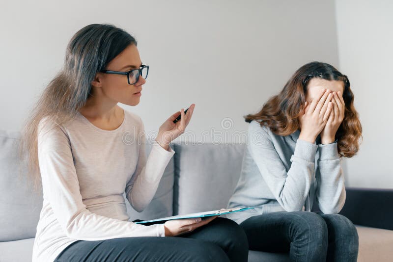 Muchacha paciente del adolescente que habla con el psicoterapeuta profesional en oficina La muchacha está trastornada, ella cubri imagen de archivo libre de regalías Muchacha paciente del adolescente que habla con el psicoterapeuta profesional en oficina La muchacha está trastornada, ella cubri imagen de archivo libre de regalías