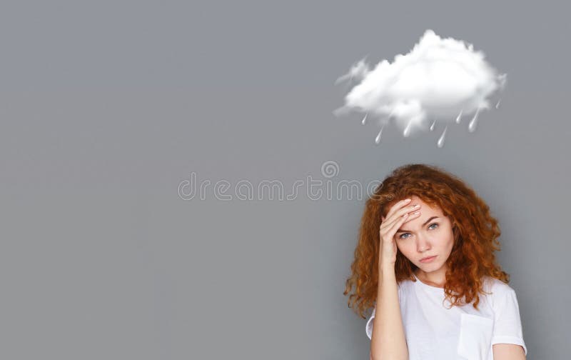 Muchacha pelirroja que lleva a cabo su cabeza con la mano debajo de la nube lluviosa fotos de archivo Muchacha pelirroja que lleva a cabo su cabeza con la mano debajo de la nube lluviosa fotos de archivo