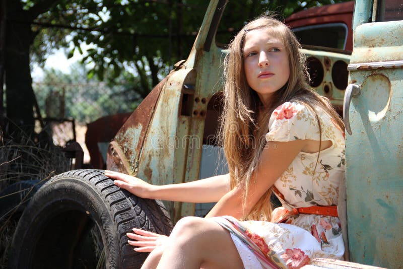 Muchacha pensativa del país de un coche roto viejo foto de archivo Muchacha pensativa del país de un coche roto viejo foto de archivo