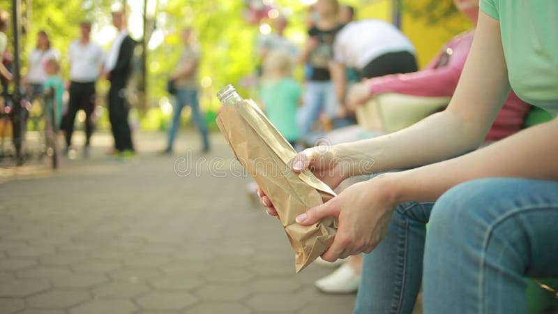 Muchacha que bebe de una bolsa de papel en la calle comportamiento antisocial