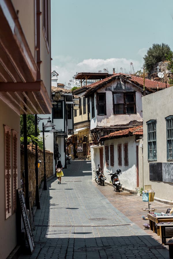 Muchacha que camina abajo de la calle soleada de la ciudad vieja Kaleici, Antalya, Turquía foto de archivo Muchacha que camina abajo de la calle soleada de la ciudad vieja Kaleici, Antalya, Turquía foto de archivo