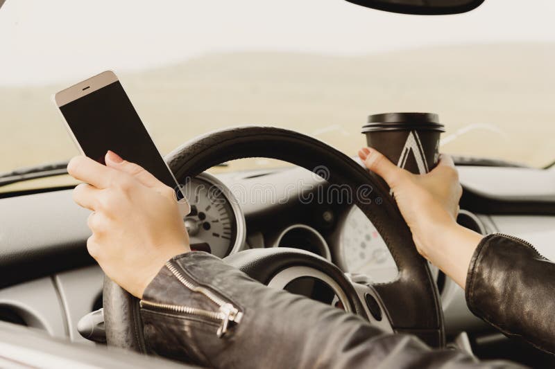 Muchacha que conduce un texto que mecanografía del coche en el teléfono y que mira hacia fuera la ventana imágenes de archivo libres de regalías Muchacha que conduce un texto que mecanografía del coche en el teléfono y que mira hacia fuera la ventana imágenes de archivo libres de regalías