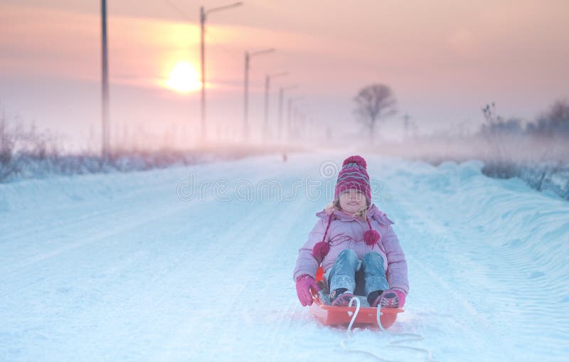 Muchacha que juega con el trineo en la nieve imágenes de archivo libres de regalías Muchacha que juega con el trineo en la nieve imágenes de archivo libres de regalías