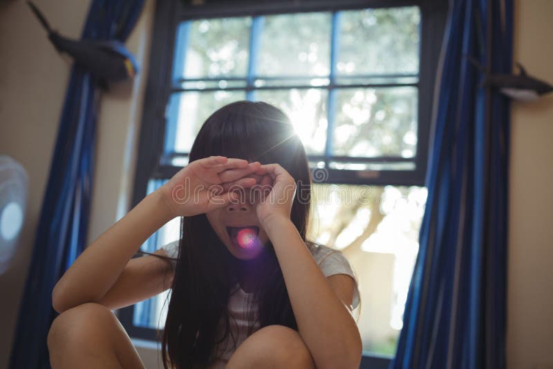 Muchacha que la cubre ojos en el cuarto de la cama fotografía de archivo Muchacha que la cubre ojos en el cuarto de la cama fotografía de archivo