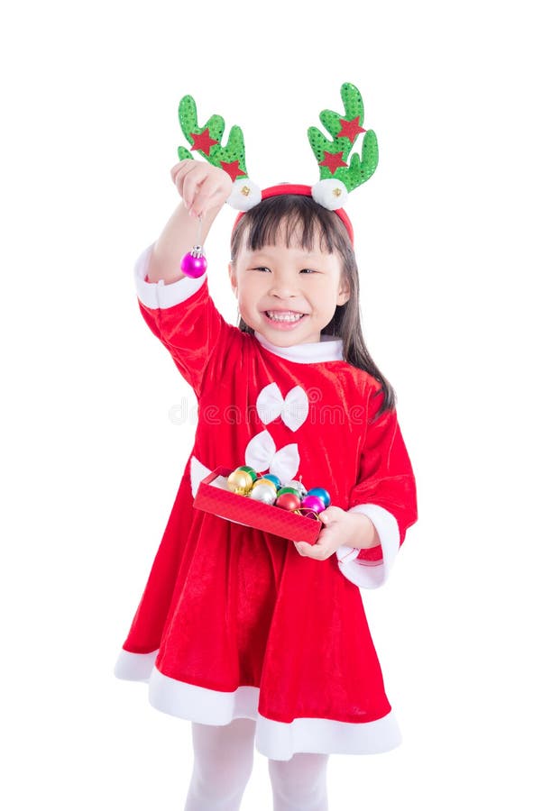 Muchacha que lleva el vestido de Papá Noel que sostiene la bola para la decoración imagen de archivo libre de regalías Muchacha que lleva el vestido de Papá Noel que sostiene la bola para la decoración imagen de archivo libre de regalías