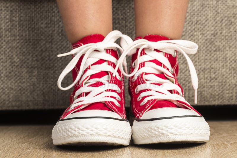 Muchacha que lleva un par de zapatillas de deporte rojas imagen de archivo libre de regalías Muchacha que lleva un par de zapatillas de deporte rojas imagen de archivo libre de regalías