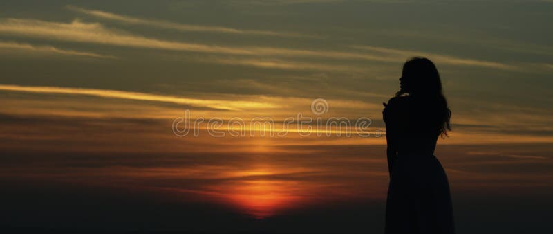Muchacha que mira puesta del sol foto de archivo Muchacha que mira puesta del sol foto de archivo