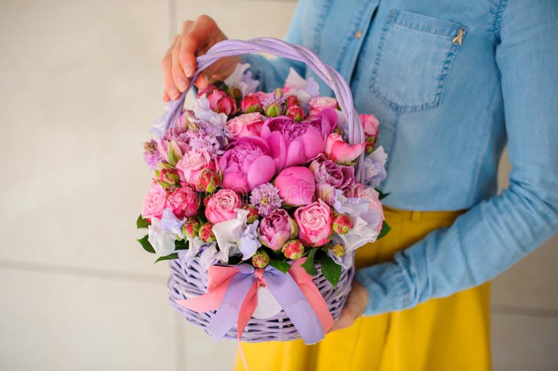 Muchacha que sostiene el ramo rosado hermoso de flores mezcladas en cesta imágenes de archivo libres de regalías Muchacha que sostiene el ramo rosado hermoso de flores mezcladas en cesta imágenes de archivo libres de regalías
