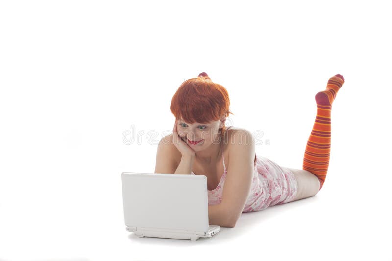 Red Girl in stripe socks with laptop on white background. Red Girl in stripe socks with laptop on white background