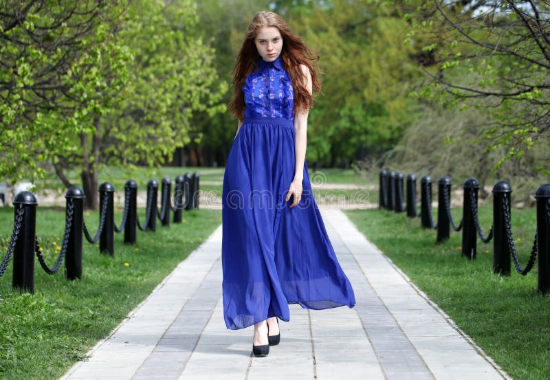 Muchacha roja hermosa del pelo en un vestido azul foto de archivo libre de regalías Muchacha roja hermosa del pelo en un vestido azul foto de archivo libre de regalías