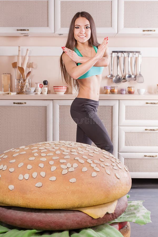 Muchacha sana que lucha contra la hamburguesa imagenes de archivo Muchacha sana que lucha contra la hamburguesa imagenes de archivo