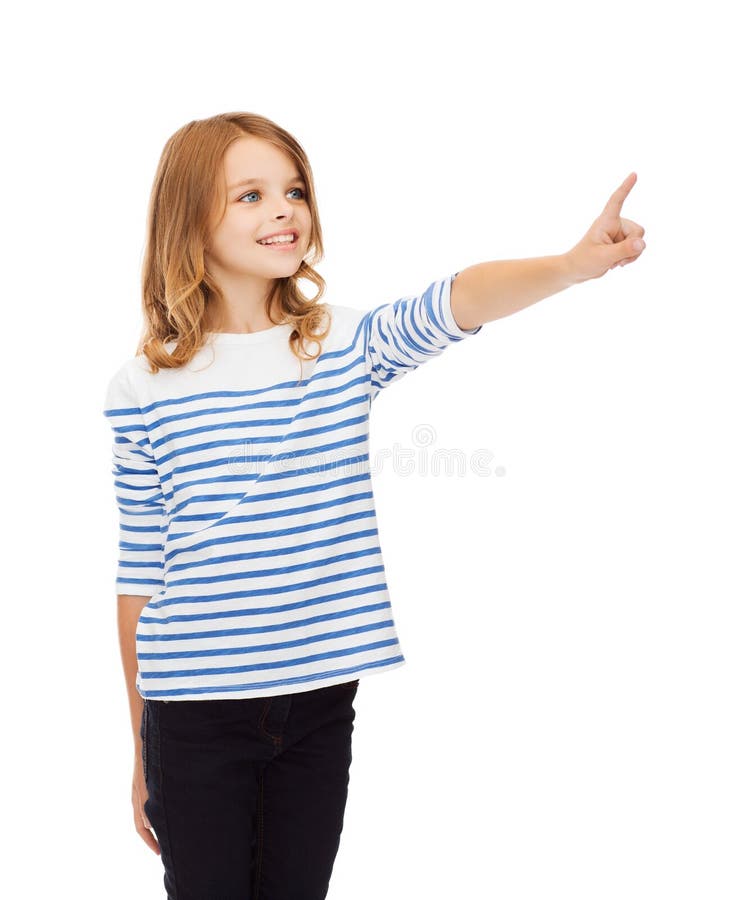 Education, school and virtual screen concept - cute little girl pointing in the air or virtual screen. Education, school and virtual screen concept - cute little girl pointing in the air or virtual screen