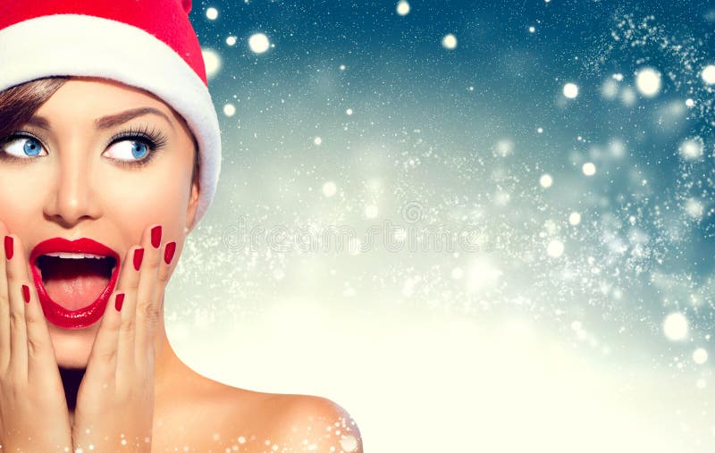 Muchacha sorprendida de la Navidad Mujer de la belleza en sombrero del ` s de Papá Noel fotografía de archivo