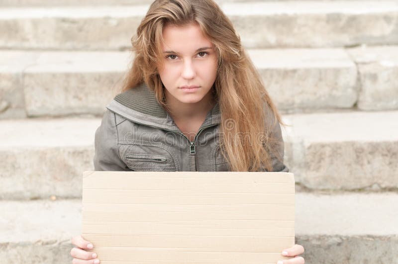 Muchacha triste joven al aire libre con la muestra en blanco de la cartulina. fotografía de archivo libre de regalías Muchacha triste joven al aire libre con la muestra en blanco de la cartulina. fotografía de archivo libre de regalías