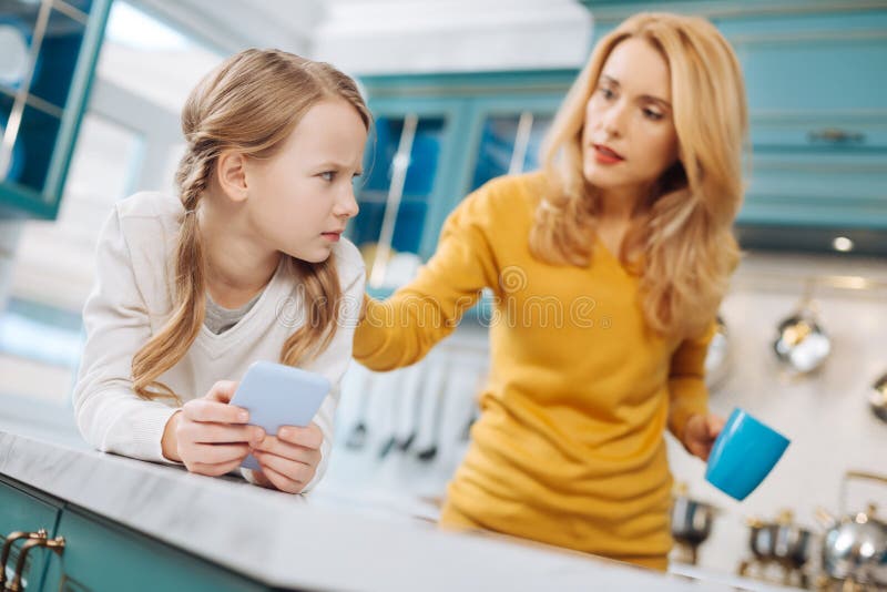 Muchacha triste que sostiene un teléfono móvil foto de archivo Muchacha triste que sostiene un teléfono móvil foto de archivo