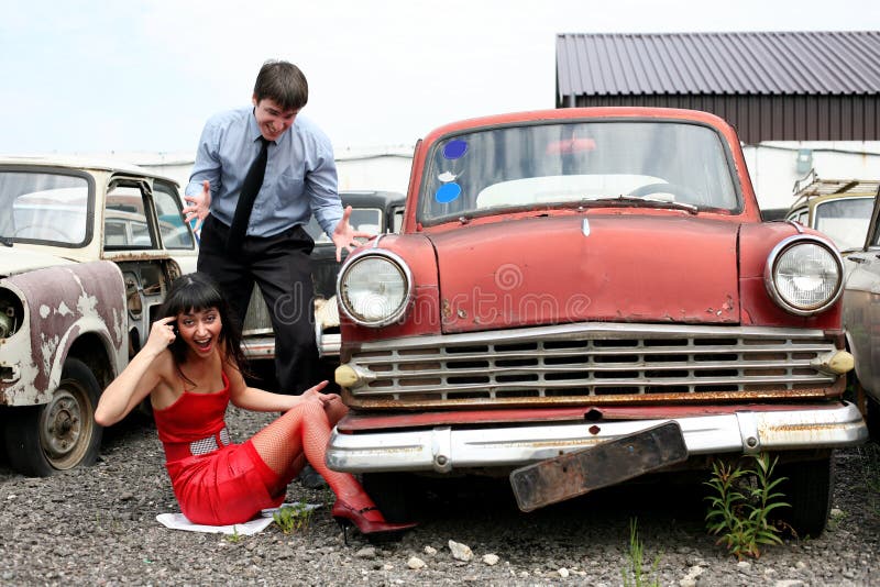 Girl and man beside retro car- under constructions to wheel. Girl and man beside retro car- under constructions to wheel