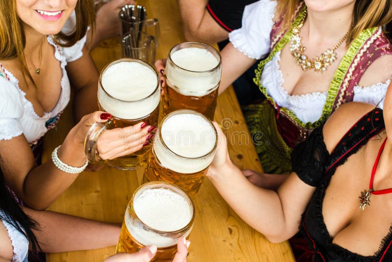 Muchachas bávaras que beben la cerveza foto de archivo Muchachas bávaras que beben la cerveza foto de archivo