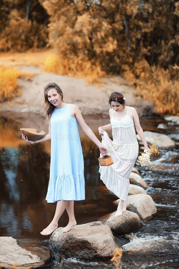 Muchachas en vestidos en otoño en el río imágenes de archivo libres de regalías