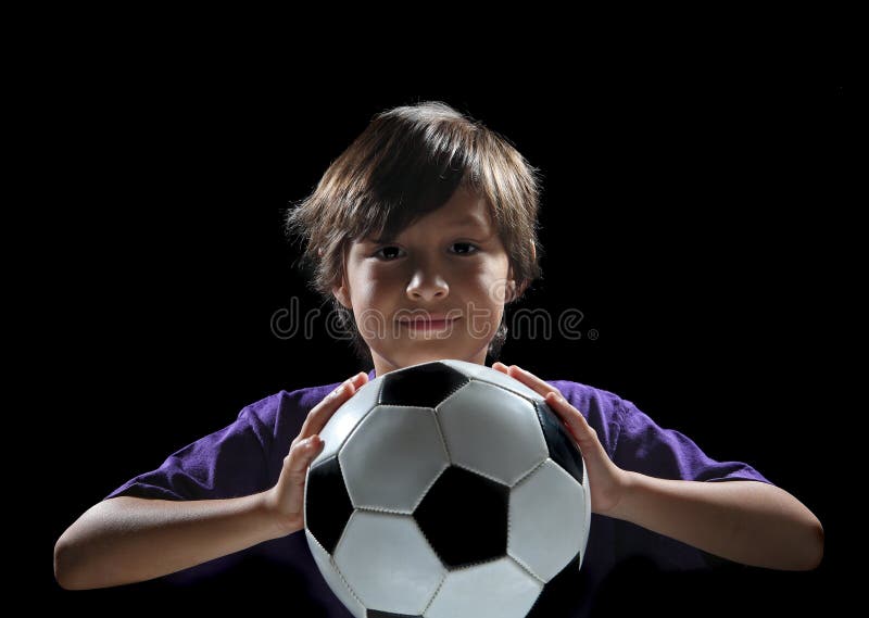 Muchacho con el balón de fútbol en fondo oscuro foto de archivo libre de regalías Muchacho con el balón de fútbol en fondo oscuro foto de archivo libre de regalías