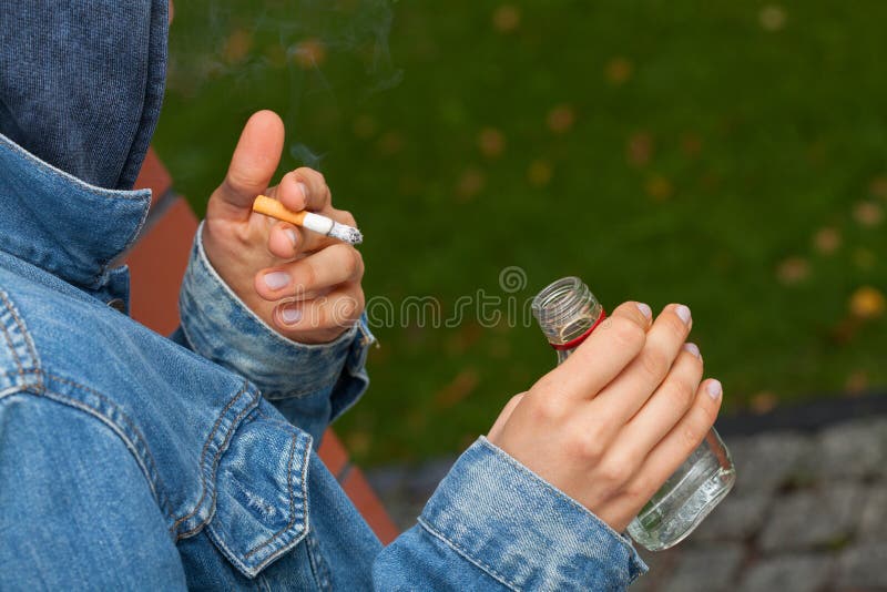 Muchacho con la vodka y el cigarrillo fotografía de archivo libre de regalías Muchacho con la vodka y el cigarrillo fotografía de archivo libre de regalías
