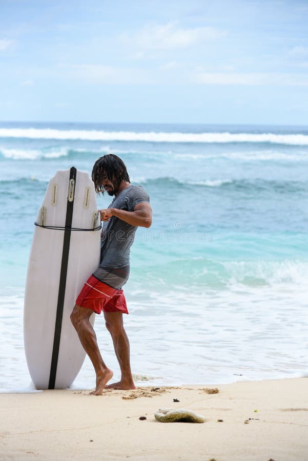 Muchacho de la persona que practica surf en la playa fotos de archivo libres de regalías Muchacho de la persona que practica surf en la playa fotos de archivo libres de regalías
