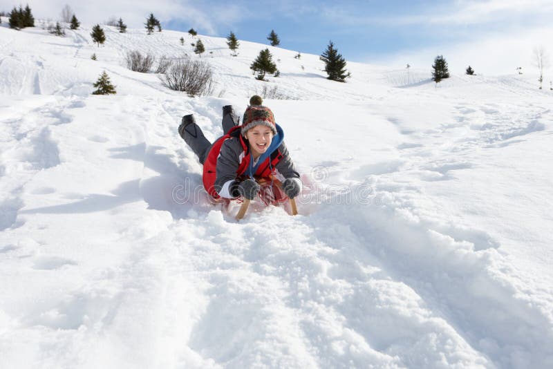 Muchacho del Pre-teen en un trineo en la nieve imagen de archivo Muchacho del Pre-teen en un trineo en la nieve imagen de archivo